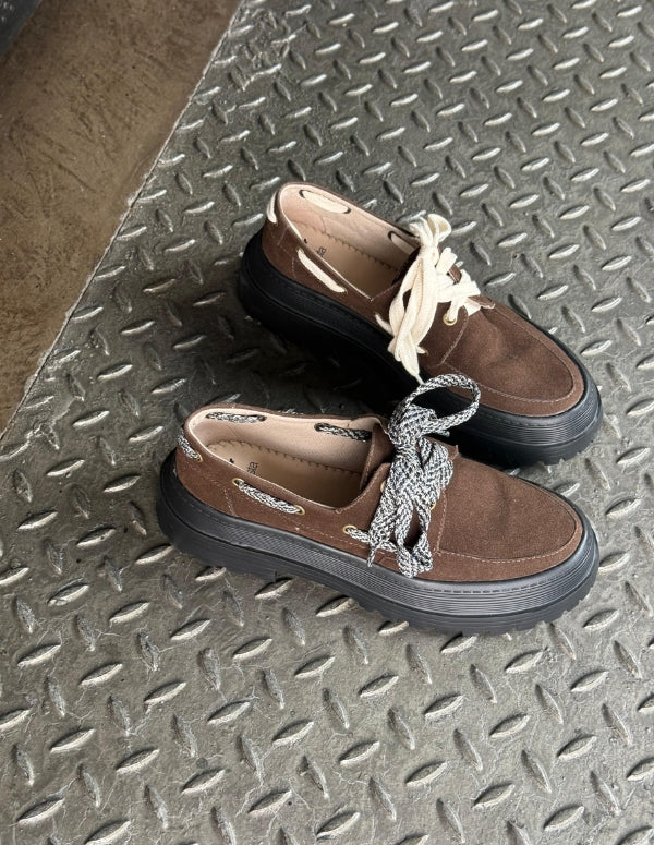 Par de Mocasines Apache Chunky Café de Animalista sobre escalera metálica, mostrando la opción de cordones intercambiables. Zapatos veganos de plataforma track y diseño en Medelln