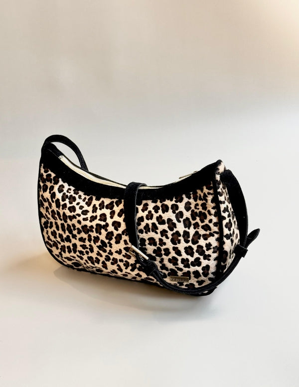 Bolso manos libres con estampado animal print leopardo y detalles en negro. Cartera vegana de diseño estructurado.