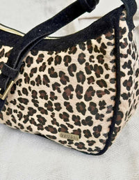 Acercamiento a la textura suave y acabados impecables del bolso hobo animal print negro.