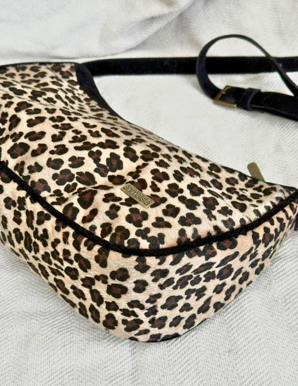 Vista superior de bolso cruzado con estampado de leopardo y correa negra. Accesorio versátil y consciente.