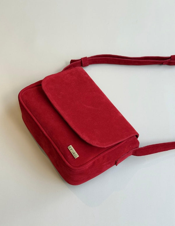 Bolso manos libres rojo para mujer con textura suave. Diseño estructurado y 100% vegano.