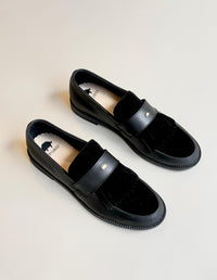 Vista superior de mocasines negros de moda ética, calzado plano ideal para la oficina.