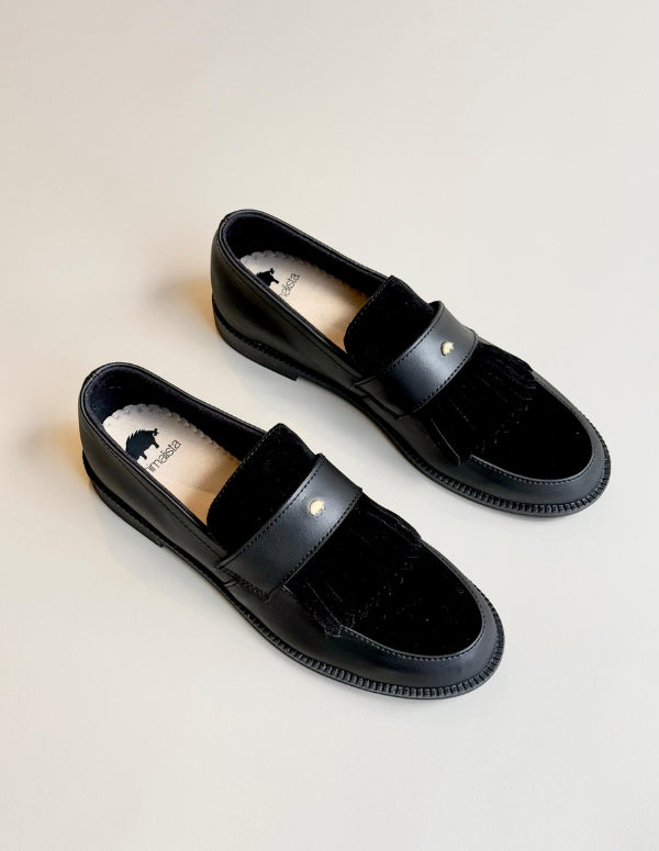 Vista superior de mocasines negros de moda ética, calzado plano ideal para la oficina.
