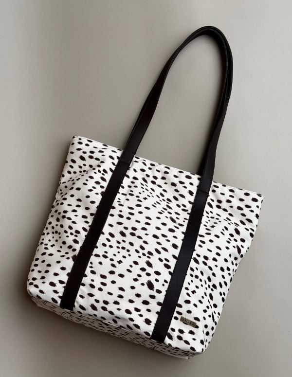 Bolso grande tipo tote bag para mujer con estampado animal print de manchas y asas negras. Bolso amplio vegano hecho en Colombia.