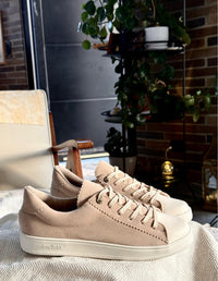 Vista lateral de tenis casuales Animalista blancos con acento tejido beige, cordones a tono y suela blanca. Diseño atemporal y cómodo hecho en Colombia.