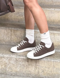 Mujer luciendo Tenis Sweet Café Oscuro de Animalista con cordones y puntera blanca en contraste. Calzado casual, vegano y de diseño local.