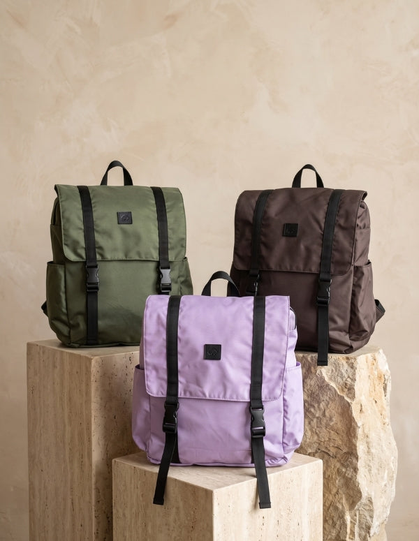 Colección de morrales utilitarios modelo Work Sport en colores verde oliva, lila y café oscuro sobre bases rústicas   . Mochilas veganas de Animalista.