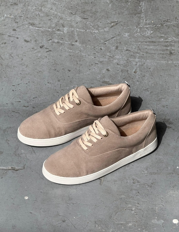 Par de zapatos casuales estilo pisahuevos para hombre color arena con suela blanca y cordones. Calzado vegano.
