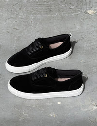 Par de zapatos pisahuevos negros de hombre sobre superficie de concreto. Diseño local colombiano.