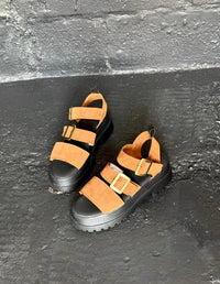 Par de sandalias chunky para mujer color miel con plataforma gruesa negra y correas con hebillas. Calzado cómodo vegano hecho en Colombia.