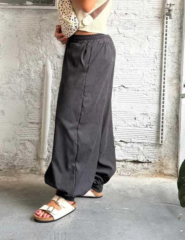 Mujer vistiendo un pantalón negro holgado y luciendo las Sandalias Mar Beige de Animalista