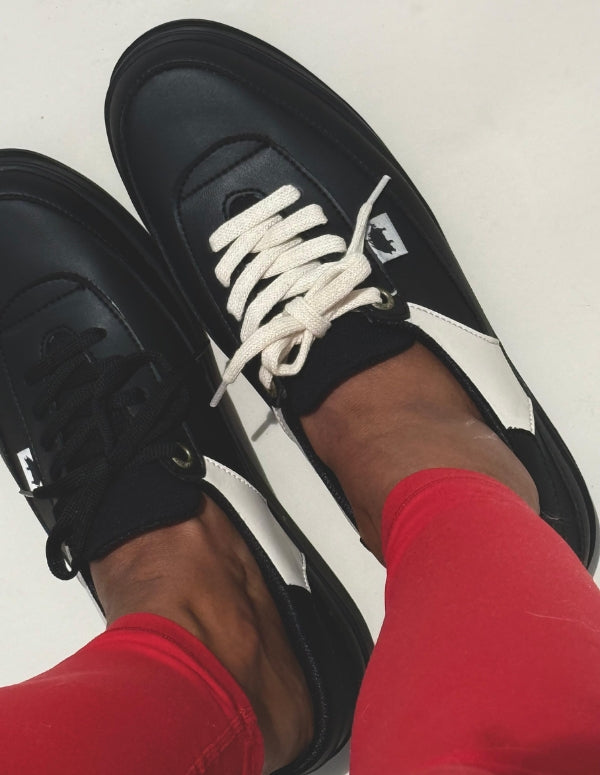 Mujer vistiendo un pantalón rojo vibrante y luciendo los Tenis Cool Negro de estilo retro de Animalista.